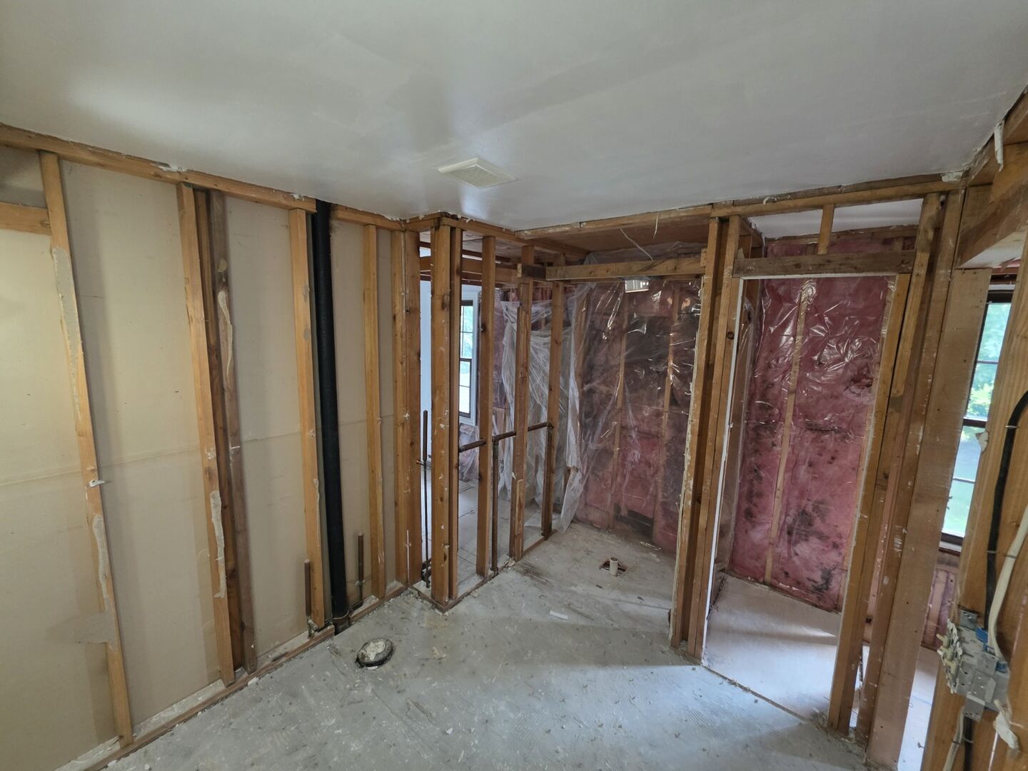 Interior demolition exposing wall studs and ceiling framing